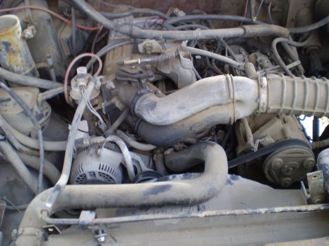1969 Ford F-250 - Close-up view of a dusty engine bay, showing various components and hoses. The Supermotors.net logo is visible at the bottom.