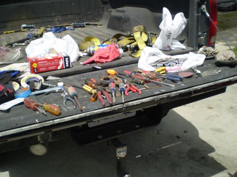 1969 Ford F-250 - Tools and equipment are spread across the tailgate and bed of a pickup truck.