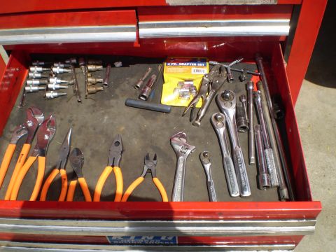 1969 Ford F-250 - A red tool chest drawer is open, revealing an assortment of hand tools including pliers, wrenches, and socket sets.