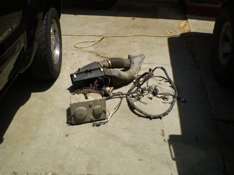 1969 Ford F-250 - Disassembled vehicle air intake system and associated wiring harness components are shown on a concrete surface.