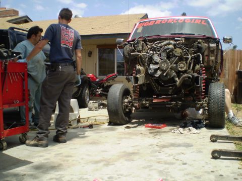 1969 Ford F-250 - Truck undergoing engine work with a motorcycle nearby. "BIGBRONCO GIRL" text visible.