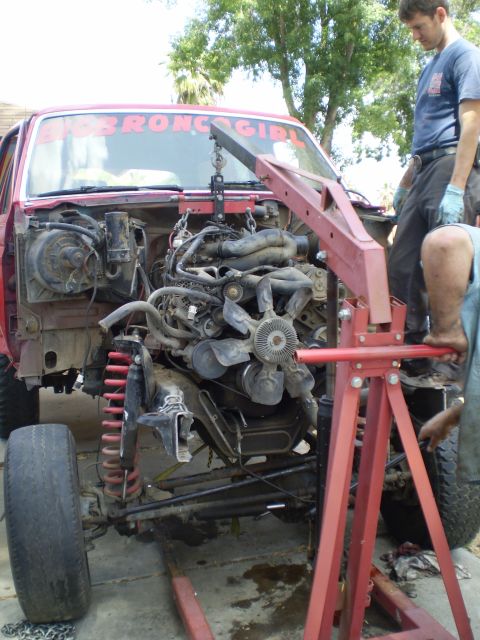 1969 Ford F-250 - Engine removal in progress on a red truck, with "BIG BRONC GIRL" visible on the windshield.