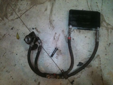 1989 Ford Bronco - This assembly includes an oil cooler, hoses, and a filter, likely for a vehicle's engine.