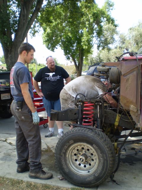 1969 Ford F-250 - Mechanics are working on the engine of a 1969 Ford F-250 truck.
