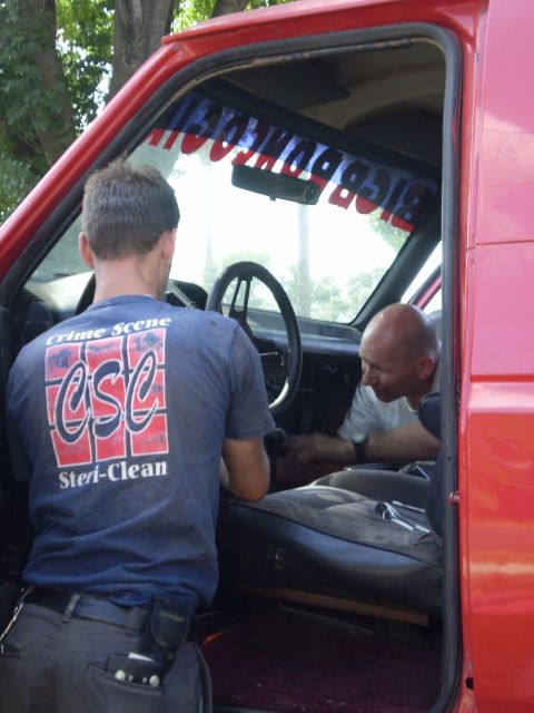 1969 Ford F-250 - Two men are working on the interior of a red truck, with one man wearing a shirt that says 'Crime Scene CSC Steri-Clean'.