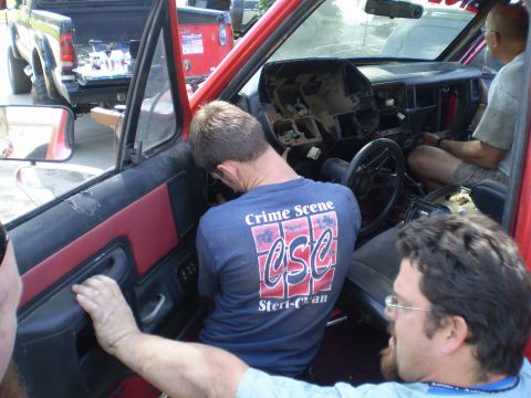 1969 Ford F-250 - Two trucks are visible, one with its interior exposed and people working on the dashboard.