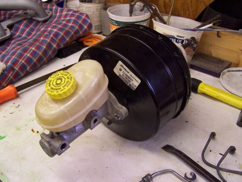 1991 Jeep Comanche - Brake booster and master cylinder assembly with a yellow cap and visible part numbers.
