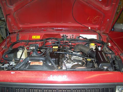 1991 Jeep Comanche - Engine bay of a 1991 Jeep Comanche, showing the engine and various components under the hood.