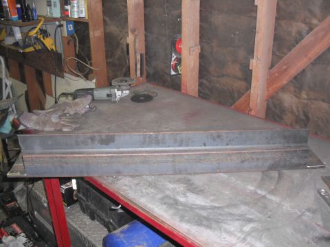 1991 Ford Bronco - Metal angle iron and an angle grinder sit on a workbench in a workshop.