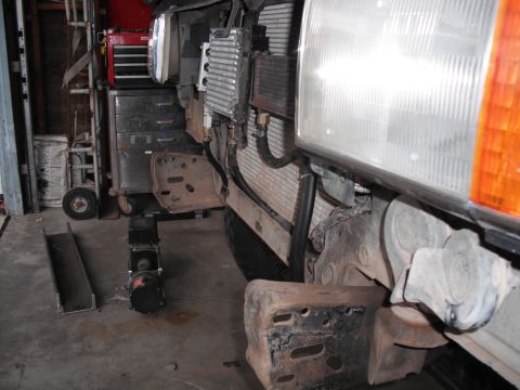 1991 Ford Bronco - The front end of a vehicle is visible, with an oil cooler installed and a bumper bracket removed.