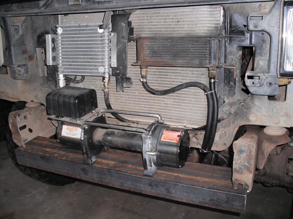 Winch mounted on metal plate in front of radiator and oil cooler