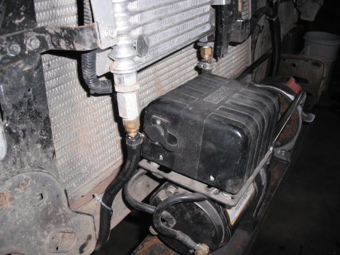 1991 Ford Bronco - Close-up of a winch and transmission cooler lines, showing plumbing and electrical connections.