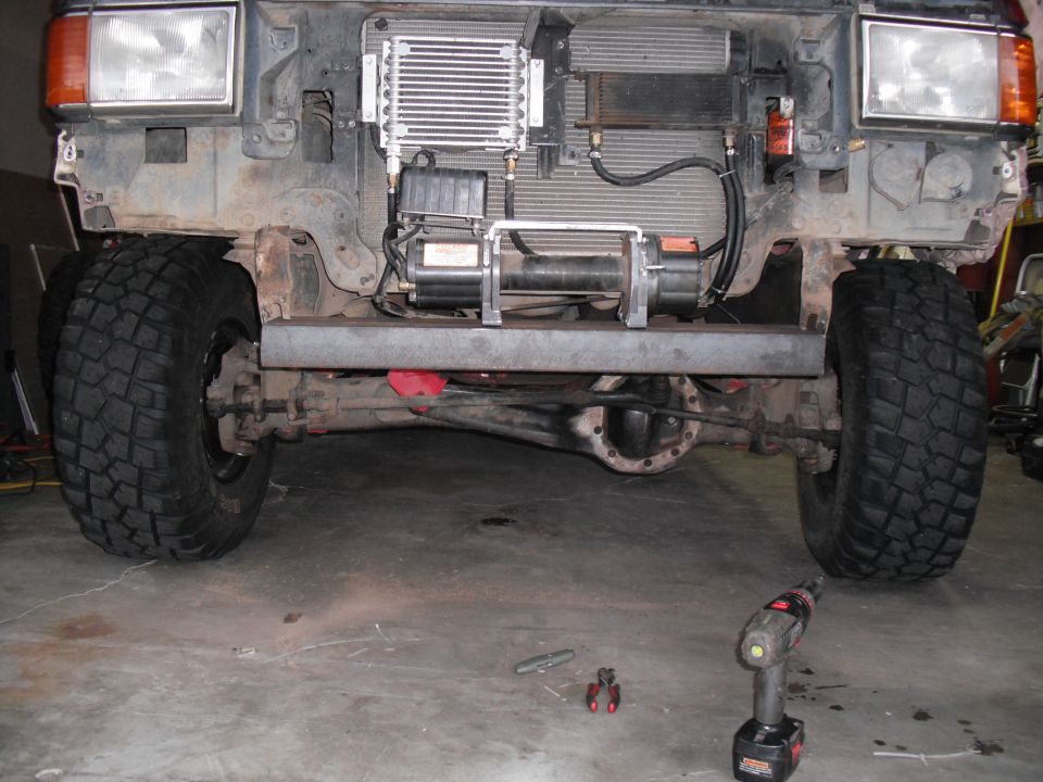 Truck front end with winch, large tires, and exposed radiator. Appears to be from the 1980s