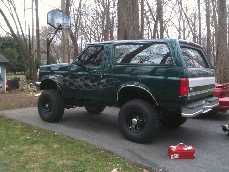 1995 Ford Bronco, lifted, green with silver flame decals on the side