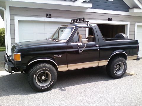 1990 Ford Bronco - This 1990 Ford Bronco is shown in a three-quarter front view, parked outside a garage.