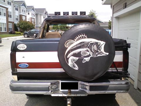1990 Ford Bronco - This Ford Bronco has a spare tire cover with a fish design and a 'save the gas' sticker on the tailgate.
