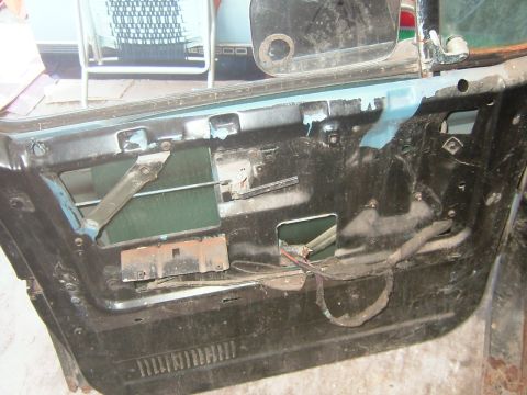 1985 Chevrolet C/K Pickup - The interior of a car door panel is shown with its internal components exposed.