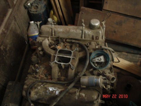 1987 Ford Bronco - This is a dusty engine, likely from an older vehicle, stored indoors with various other items.