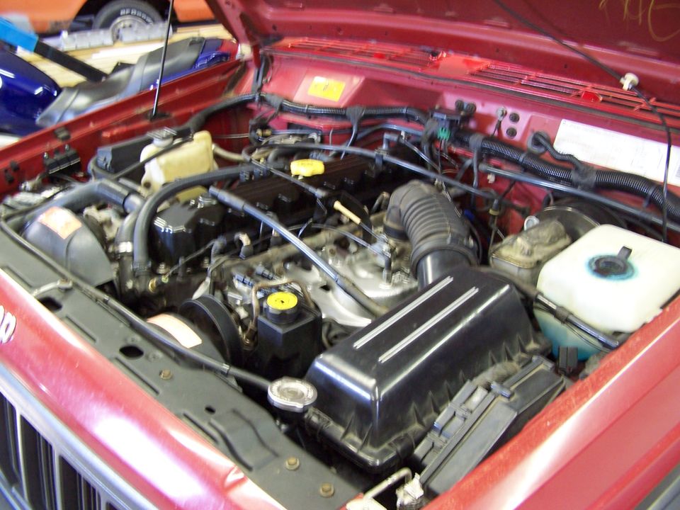 1991 Jeep Comanche engine bay with red exterior paint visible