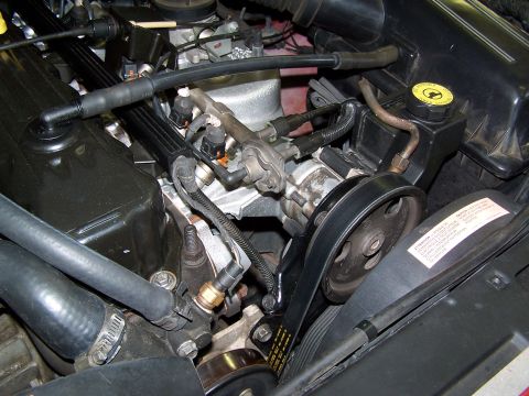 1991 Jeep Comanche - Close-up view of the engine bay of a 1991 Jeep Comanche, showing various engine components and belts.