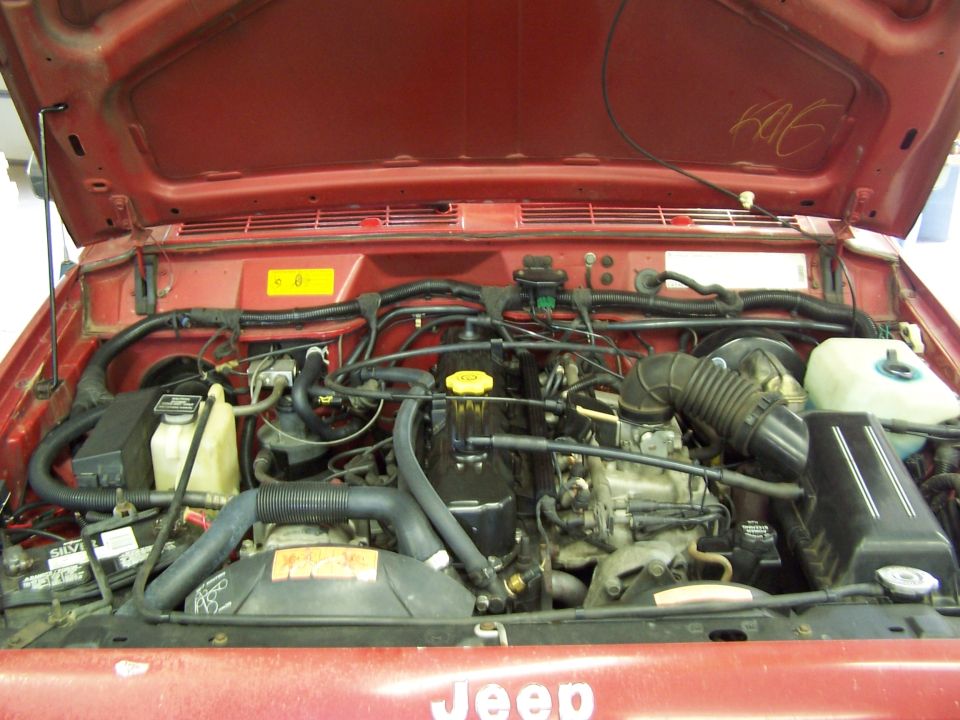 Red Jeep engine bay with visible Jeep logo on hood