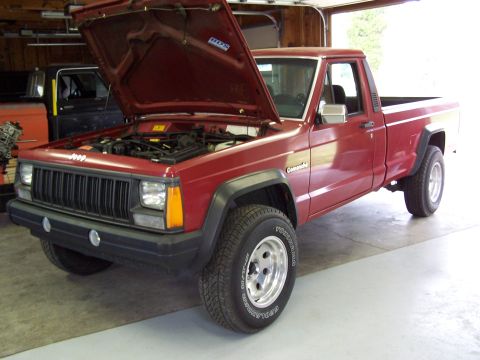 1991 Jeep Comanche - Red 1991 Jeep Comanche pickup truck with its hood open, parked in a garage.