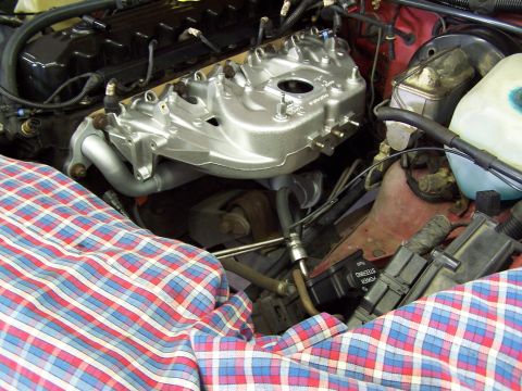 1991 Jeep Comanche - Close-up view of an engine's intake manifold and surrounding components, partially covered by a plaid cloth.