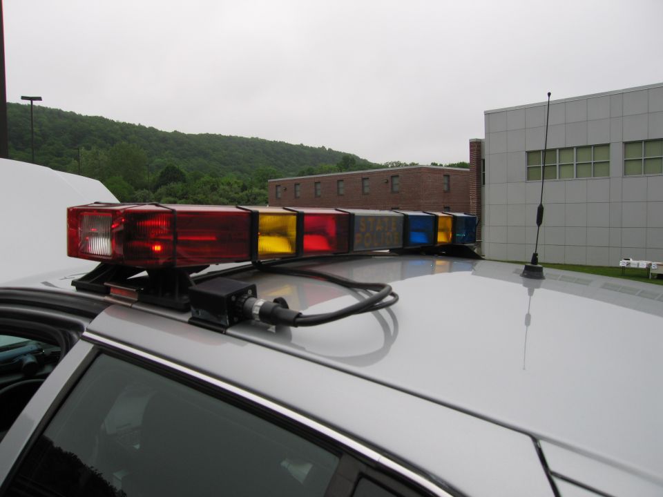 Close-up of a multicolor police light bar on a white car roof