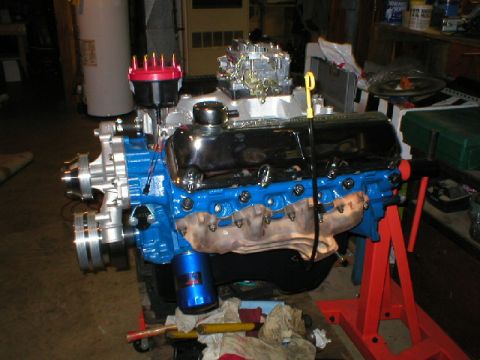 1978 Ford Bronco - A freshly rebuilt Ford V8 engine mounted on a red engine stand, featuring blue-painted block and heads, chrome valve covers, a red distribu…