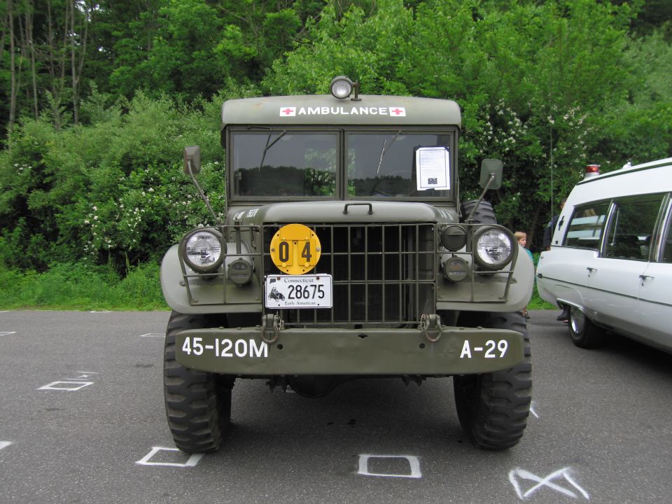 Front of olive-drab military ambulance truck with grille guard and plates