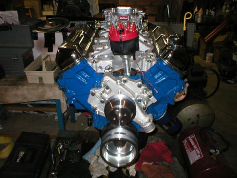 1978 Ford Bronco - Freshly assembled Ford V8 on an engine stand in a cluttered garage: blue-painted block, chrome valve covers, polished aluminum intake manif…