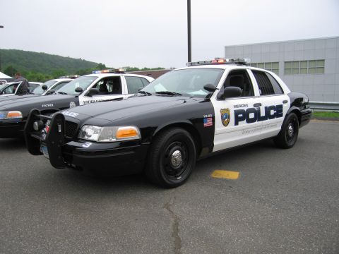 1991 Ford LTD Crown Victoria - black-and-white Meriden Police Ford Crown Victoria cruiser shown front three-quarter in a parking lot with other cruisers behind.