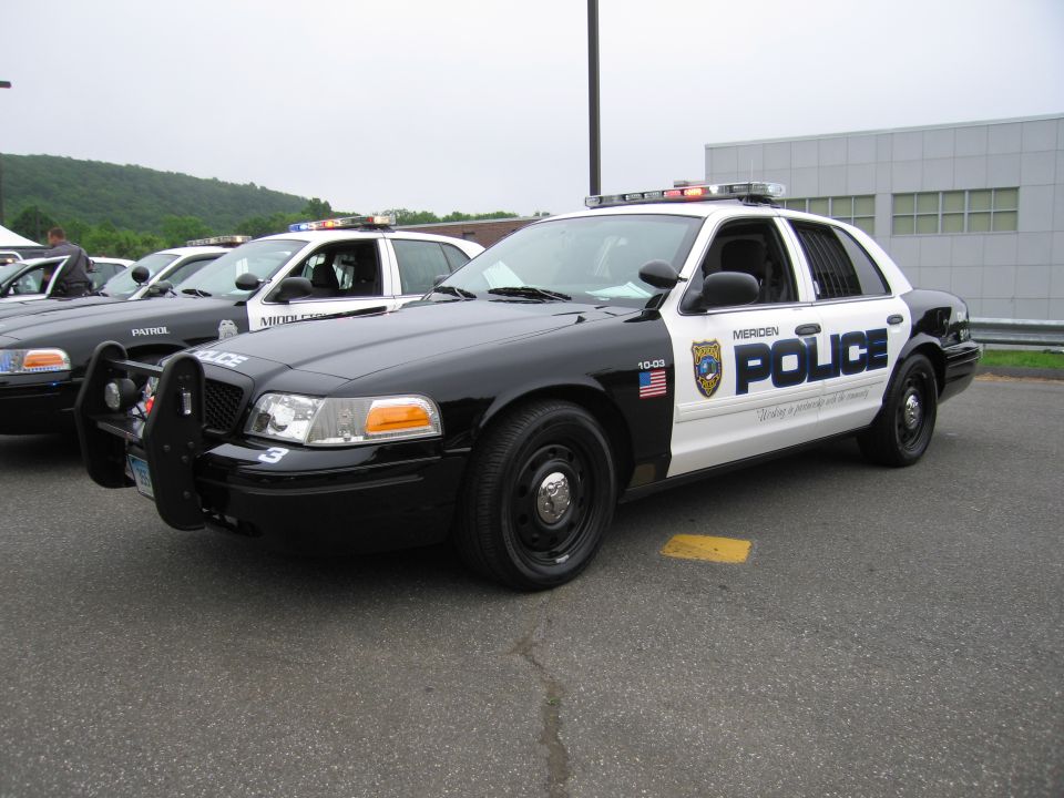 Black-and-white Meriden Police Ford Crown Victoria cruiser front three-quarter
