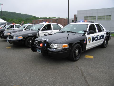 1991 Ford LTD Crown Victoria - black-and-white Meriden Police Crown Victoria cruiser in the foreground with a row of other police cars lined up behind it.