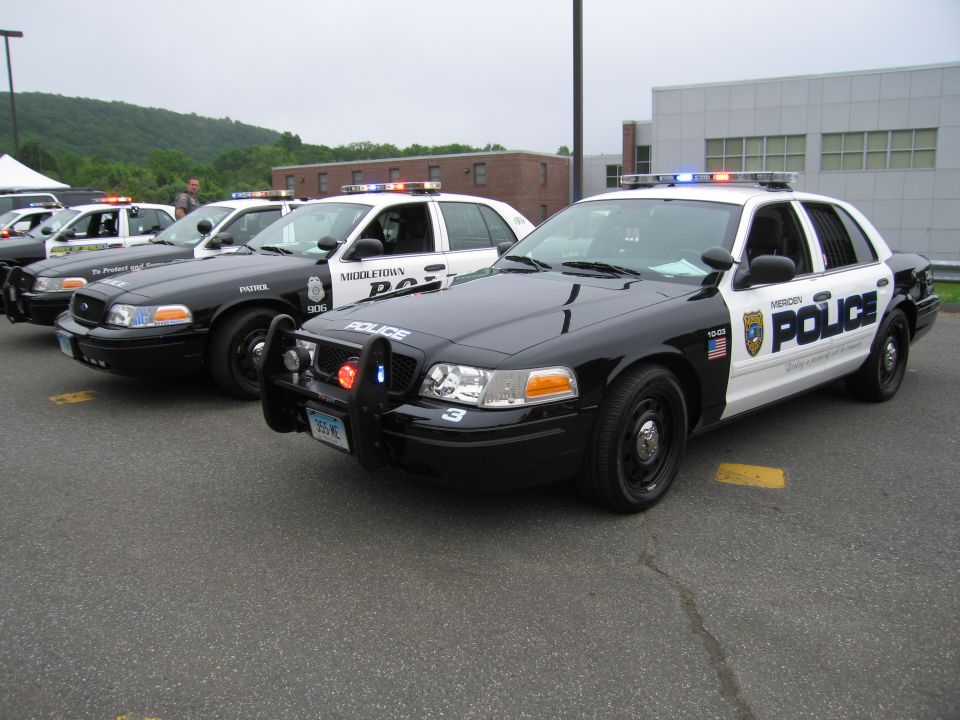 Meriden Police cruiser in front with row of other police cars behind