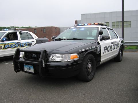 1991 Ford LTD Crown Victoria - black-and-white Police Ford Crown Victoria with a grille guard and Connecticut plate, shown front three-quarter beside another cruiser.