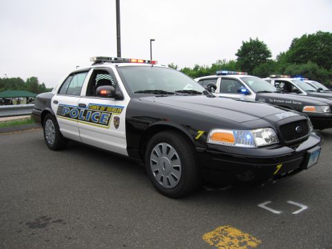 1991 Ford LTD Crown Victoria - black-and-white Town of Berlin Police Crown Victoria cruiser shown front three-quarter with light bar, with more cruisers behind.
