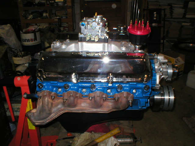 Rebuilt Ford blue V8 on an engine stand with chrome valve covers and polished intake