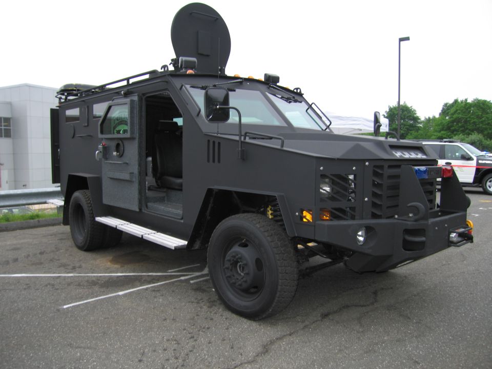 Black armored SWAT police truck with side door open and turret