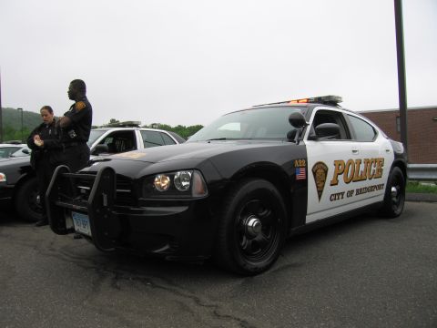 1991 Ford LTD Crown Victoria - black-and-white Dodge Charger marked 'Police City of Bridgeport' with push bar, two officers standing beside it.