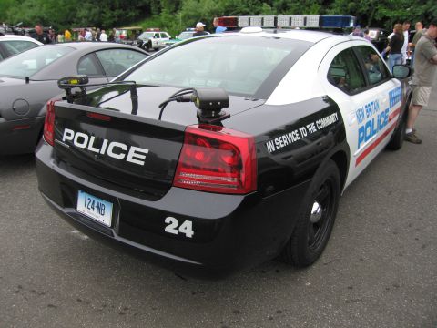 1991 Ford LTD Crown Victoria - Rear view of a black-and-white Dodge Charger lettered 'New Britain Police 24' and 'In Service To The Community' at an event.