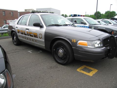1991 Ford LTD Crown Victoria - two-tone gray Ford Crown Victoria marked 'Police Simsbury 15' parked among other cruisers in a lot.