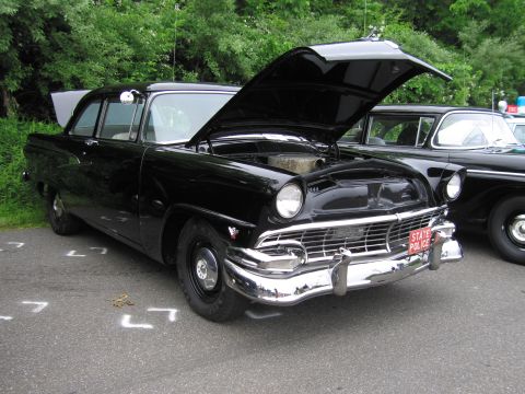 1991 Ford LTD Crown Victoria - black mid-1950s Ford two-door sedan with its hood up exposing the engine and a red 'STATE POLICE' front plate.