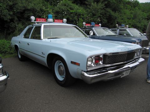 1991 Ford LTD Crown Victoria - light-blue 1970s Dodge full-size sedan State Police cruiser with roof lights, in a row of patrol cars.