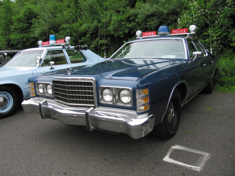 Dark blue 1970s Ford LTD State Police sedan with stacked quad headlights