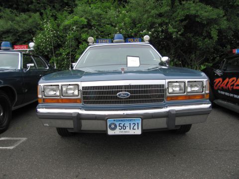 1991 Ford LTD Crown Victoria - Head-on view of a blue Ford LTD Crown Victoria State Police sedan with a Connecticut '56-121' plate and roof lights.