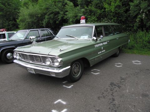 1991 Ford LTD Crown Victoria - green 1960s Ford station wagon lettered Stratford Police Radio Patrol with a roof beacon parked at a show.