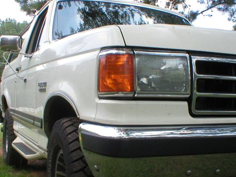 1989 Ford Bronco - This white Ford Bronco shows its 4x4 badging and front grille detail.