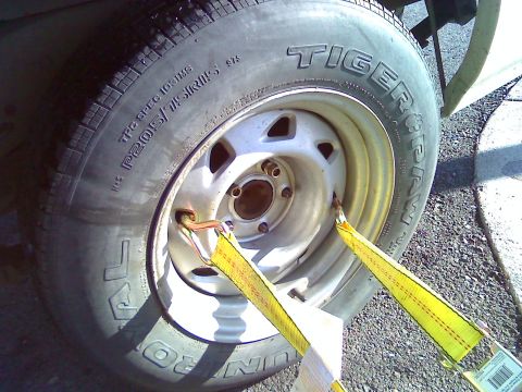 2006 Ford E350 - Tire and wheel assembly secured with tie-down straps.