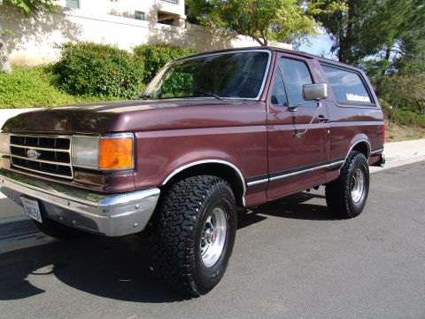 1991 Ford Bronco - This maroon 1991 Ford Bronco SUV is shown from a 3/4 front angle.